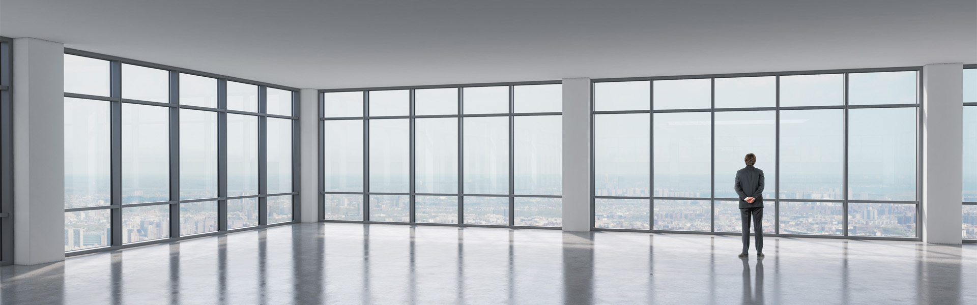 Business man looking out of empty high-rise office space